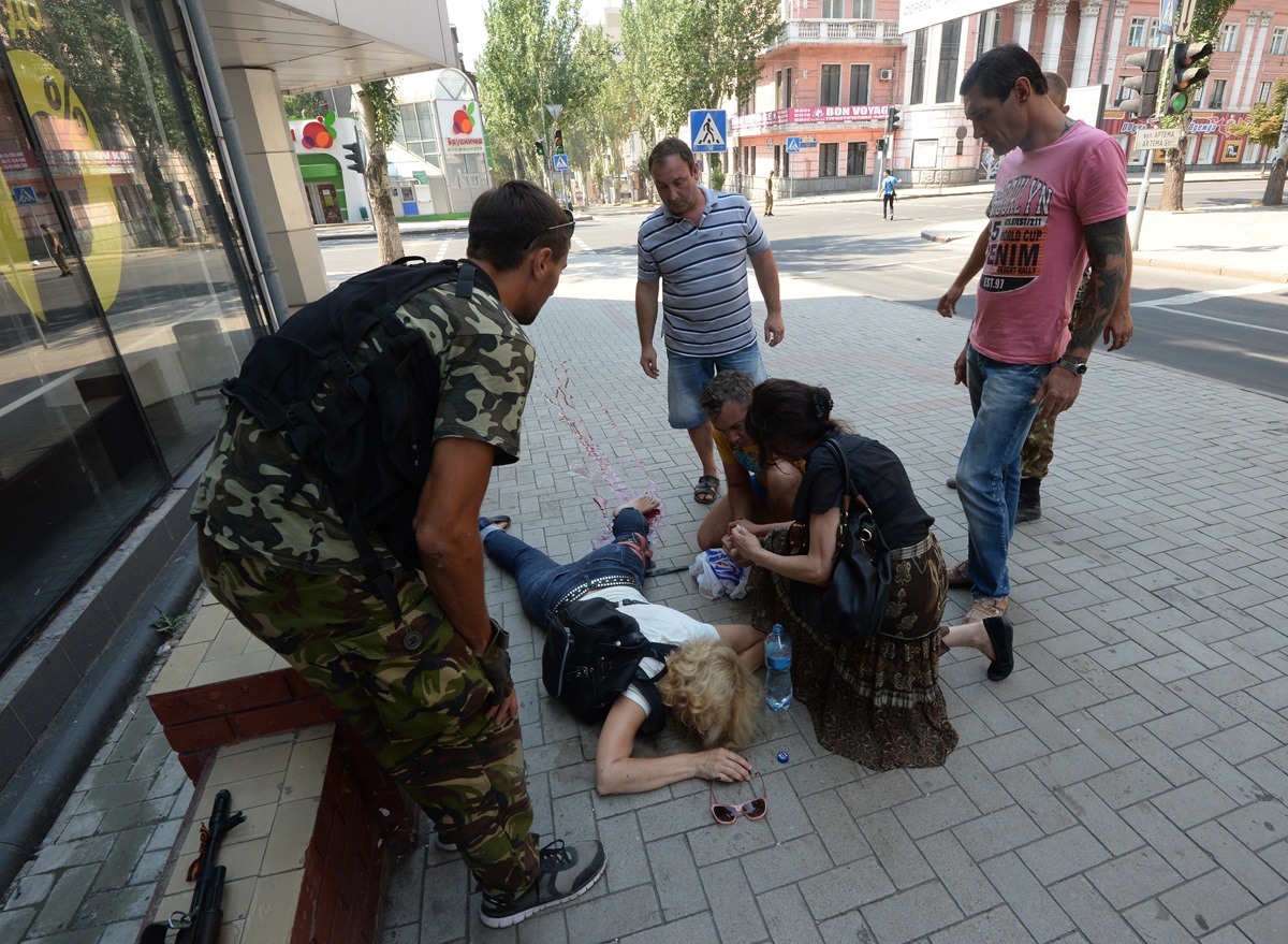 Женщине, пострадавшей во время обстрела, оказывают помощь, Донецк, 2014 год. Фото: Михаил Воскресенский /&nbsp;РИА Новости