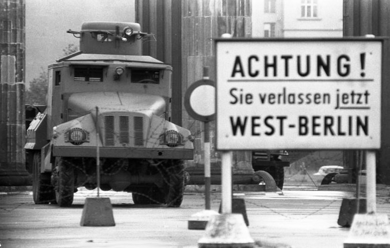 13 августа 1961 года, возле Бранденбургских ворот. Надпись на плакате: «Внимание! Вы покидаете Западный Берлин». На заднем плане абронированный автомобиль-водомет ГДР. Фото: Helmut J. Wolf / Bundesarchiv 