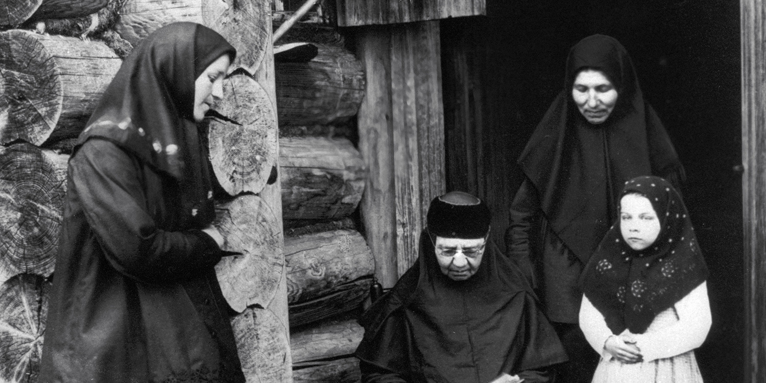 Верующие читают молитвенник на крыльце старообрядческой домовой молельни. Фото: Михаил Дмитриев / РИА Новости