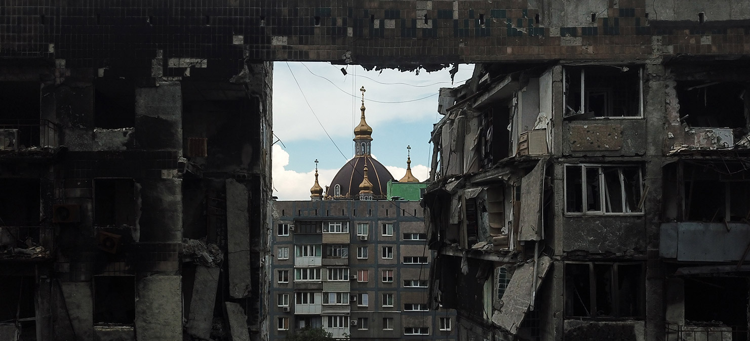 Вид на Покровский храм через разрушенный многоквартирный дом в Мариуполе. Фото: РИА Новости