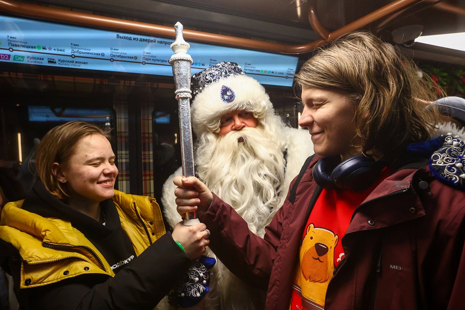 Пассажиры московского метрополитена держат посох Деда Мороза и загадывают желание. Фото: Чингаев Ярослав / Агентство «Москва»